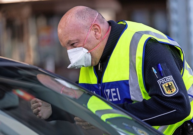 Ein Bundespolizist mit Atemmaske kontr...Schweiz in Weil am Rhein ein Fahrzeug.  | Foto: Patrick Seeger