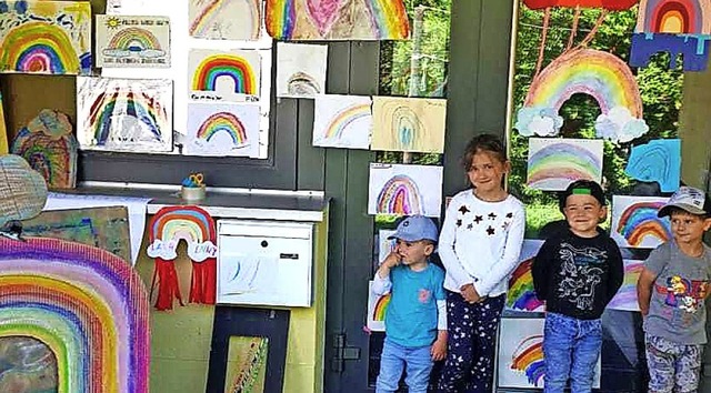 Kinder aus der Notbetreuungsgruppe am ...en mit den gemalten Regenbogenbildern.  | Foto: Cecile Buchholz