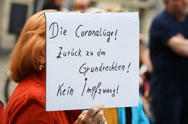 Auf einer Demonstration gegen die Man... Sonntag eine Frau dieses Schild hoch.  | Foto: Stefan Sauer (dpa)