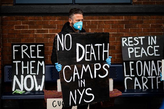 Ein Mann protestiert vor einem New Yor...id-19 Erkrankten in den Einrichtungen.  | Foto: JOHANNES EISELE