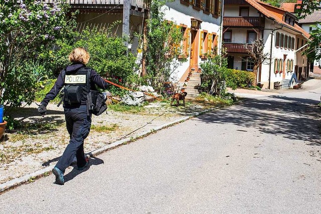 Eine Polizistin folgt mit ihrem Hund d... Spur eines Verdchtigen in Riedichen.  | Foto: Philipp von Ditfurth (dpa)