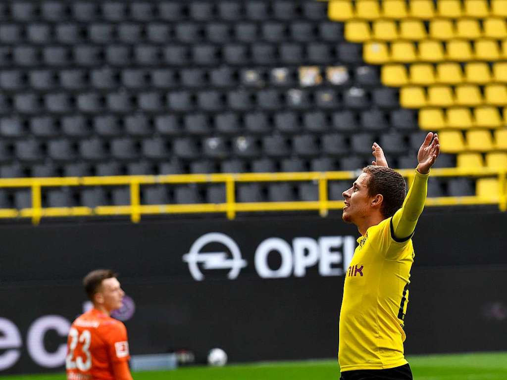 Jubel vor der leeren Wand: Der Dortmunder Thorgan Hazard stellt sich nach seinem Treffer zum 3:0 im Revierderby gegen Schalke 04 in gewohnter Manier mit ausgebreiteten Armen vor die  menschenleere Sdtribne.