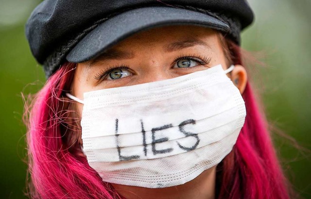 Eine Frau trgt einen Mundschutz mit d...d der Corona-Pandemie zu protestieren.  | Foto: Jane Barlow
