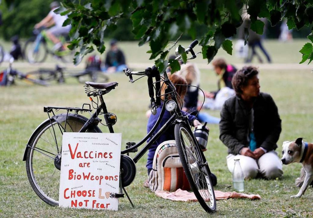 Menschen sitzen während einer Demonstr...ns&#8220; (Impfstoffe sind Biowaffen).  | Foto: Kirsty Wigglesworth (dpa)