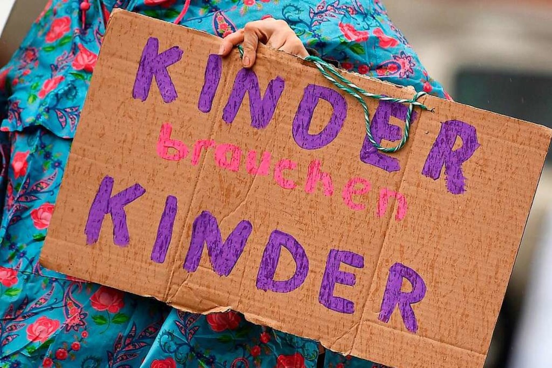 Eine Frau demonstriert in Berlin am Tag der Kinderbetreuung.  | Foto: Britta Pedersen (dpa)