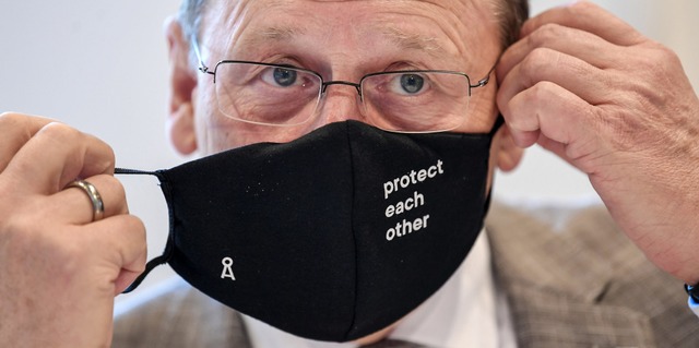 Nimmt die Maske ab: Thringens Ministe...gegenseitig zu schtzen, steht darauf.  | Foto: Martin Schutt (dpa)