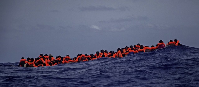Migranten warten auf dem Mittelmeer au... gegen Fluchtursachen gesucht werden.   | Foto: Santi Palacios