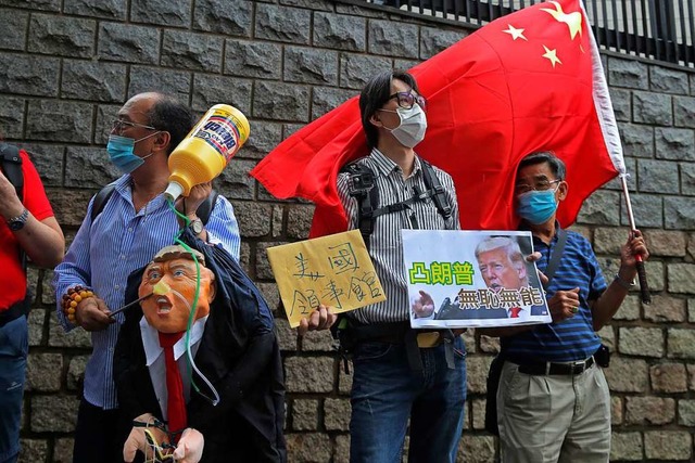 Fr Chinas Regierungsanhnger relativi... das Vorgehen der Polizei in Hongkong.  | Foto: Kin Cheung (dpa)