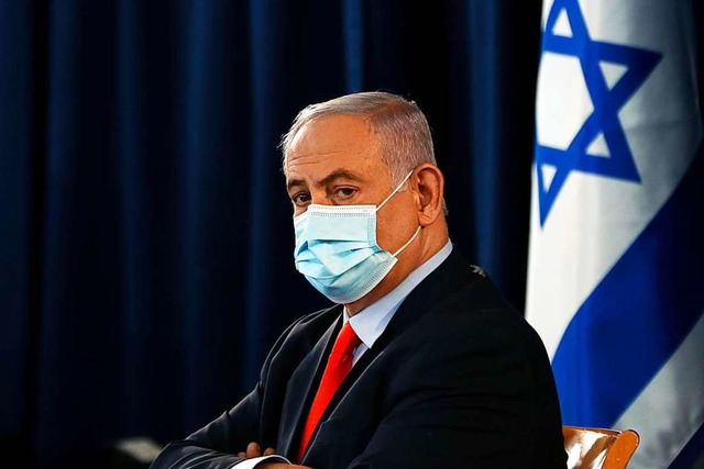 Der israelische Premier Benjamin Netan...entlichen Kabinettssitzung eine Maske.  | Foto: Ronen Zvulun (dpa)