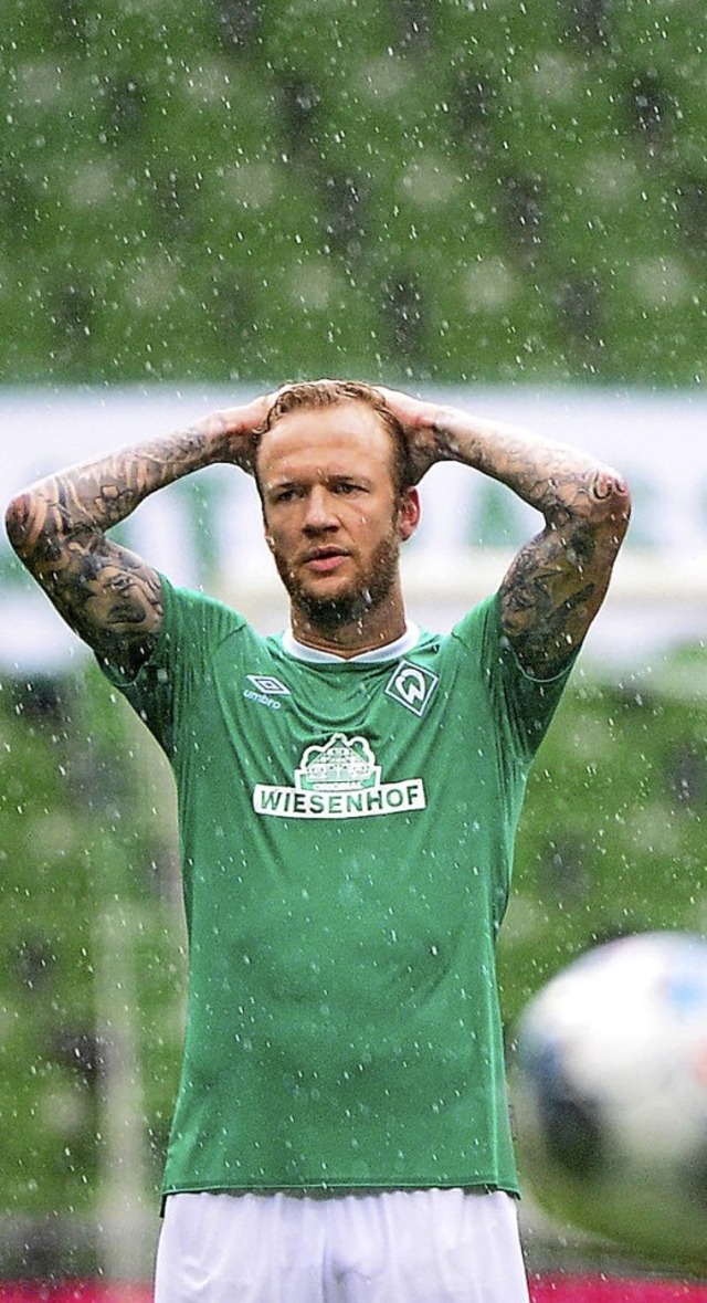 Bremens Spieler Kevin Vogt steht nach ...gegen Wolfsburg buchstblich im Regen.  | Foto: Patrik Stollarz (dpa)