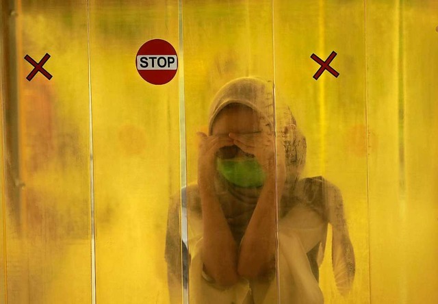 Eine Frau steht vor dem Eingang eines ...Das Foto wurde in Jakarta aufgenommen.  | Foto: Dita Alangkara (dpa)