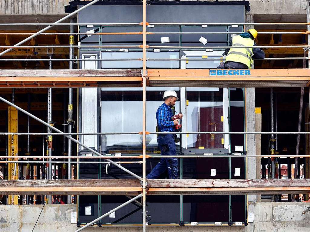 Whrend noch der Rohbau luft, montieren die Bauarbeiter schon die erste Musterfassade.