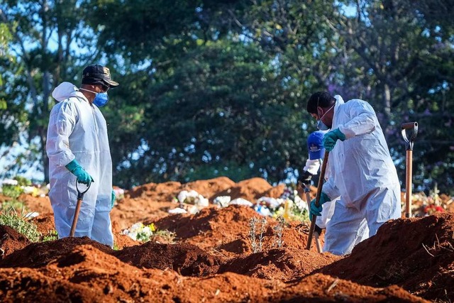 Friedhofsmitarbeiter in Schutzanzgen ...dem Friedhof Vila Formosa in Sao Paulo  | Foto: Lincon Zarbietti (dpa)