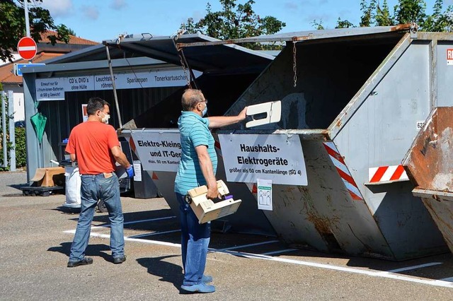 Mnner entsorgen Abfall in den Containern des Recyclinghofs Werderstrae.  | Foto: Horatio Gollin