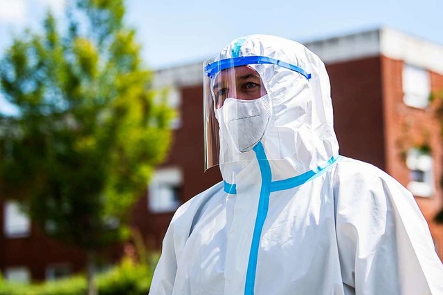 Ein Bundeswehr-Soldat im Schutzanzug u...ersonen auf das Coronavirus zu testen.  | Foto: David Inderlied (dpa)