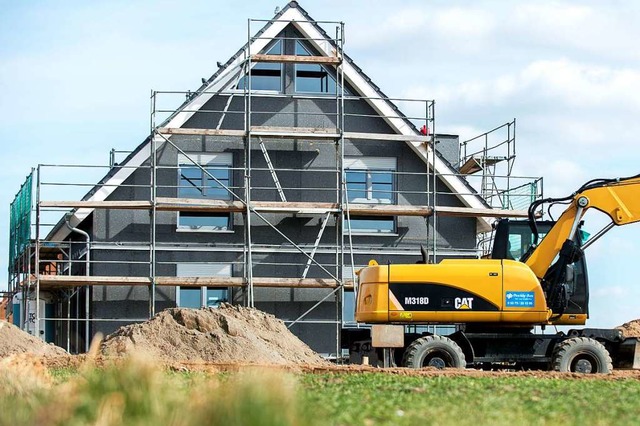 Ein eingersteter Rohbau eines Einfamilienhauses steht in einem Neubaugebiet.  | Foto: Hauke-Christian Dittrich (dpa)