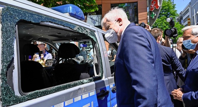 Ortstermin in Stuttgart: Bundesinnenmi...auptstadt ein demoliertes Polizeiauto.  | Foto: THOMAS KIENZLE (AFP)