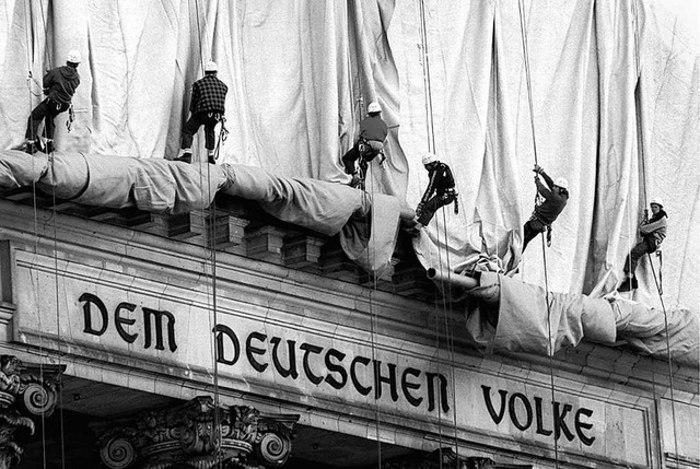 Eine Seilschaft rollt die Verhllungsplanen fr den Berliner Reichstag ab.  | Foto: Wolfgang Kumm (dpa)