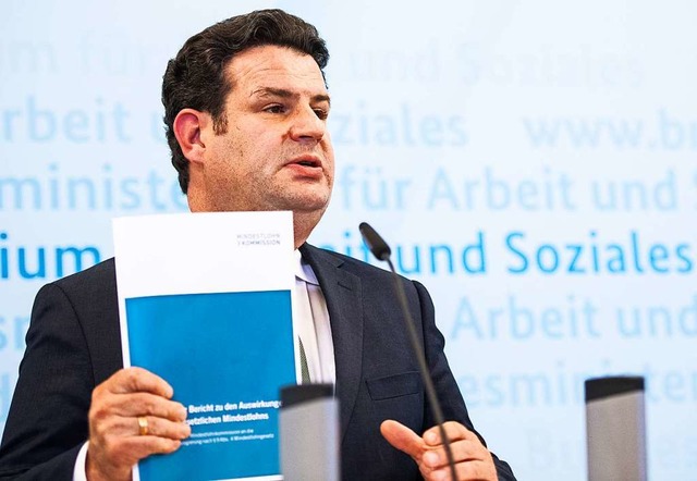 Hubertus Heil (SPD), Bundesminister f...sion und hlt den Bericht in der Hand.  | Foto: Christophe Gateau (dpa)