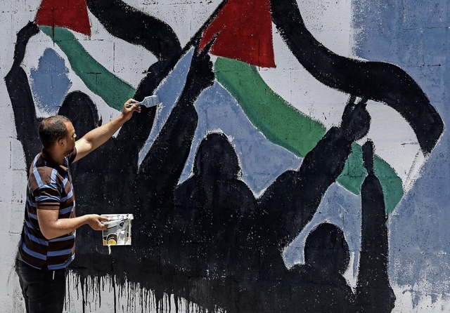 Protest mit dem Pinsel: Ein palstinen...inem Mauerbild gegen Netanjahus Plne.  | Foto: SAID KHATIB (AFP)