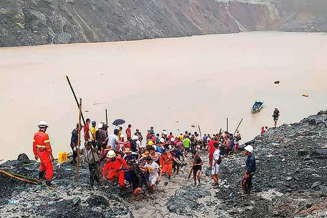 Rettungskrfte sind nach einem Erdrutsch in einem Jade-Bergwerk im Einsatz.  | Foto:  (dpa)