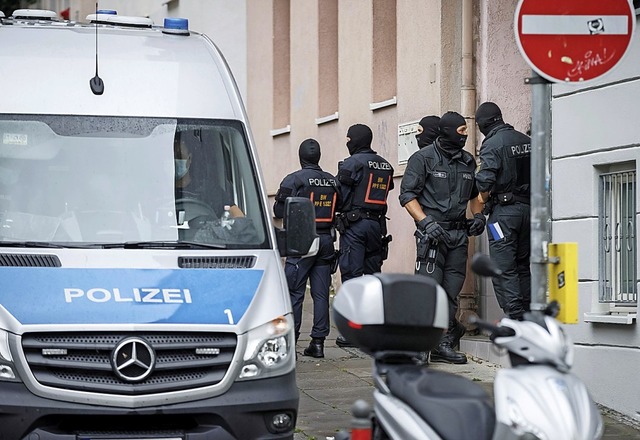 Polizisten am Donnerstag bei einer Hausdurchsuchung in Stuttgart  | Foto: Julian Rettig (dpa)