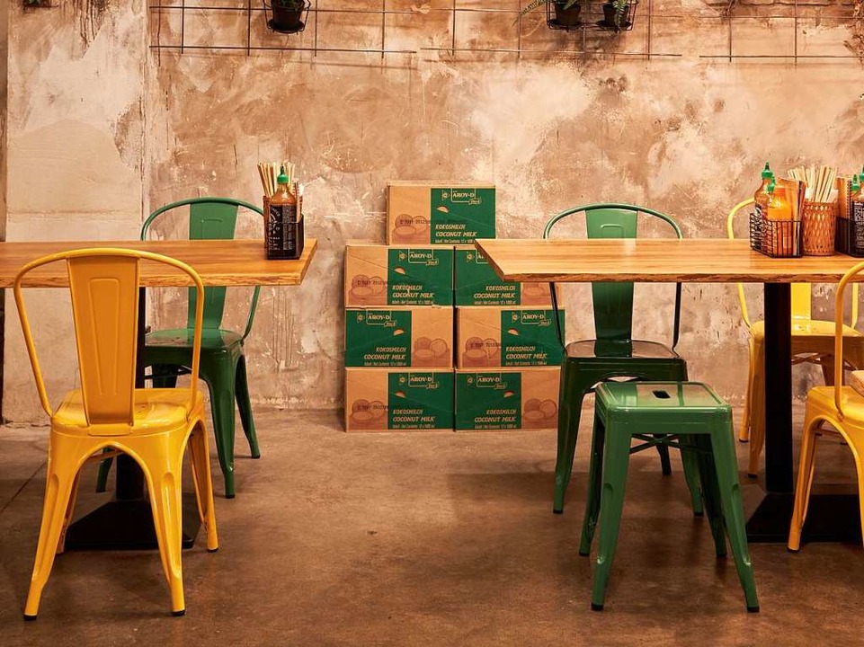 Grün- und gelbfarbene Stühle, Bastlampen, terracottafarbene Wände und viel Grün  | Foto: Djamel Kramcha