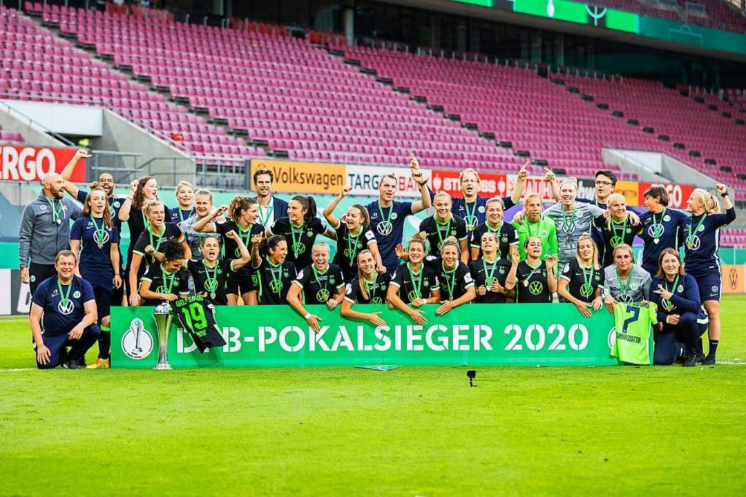 Die Wolfsburgerinnen jubeln nach dem 7...g nach Elfmeterschießen mit dem Pokal.  | Foto: Rolf Vennenbernd (dpa)
