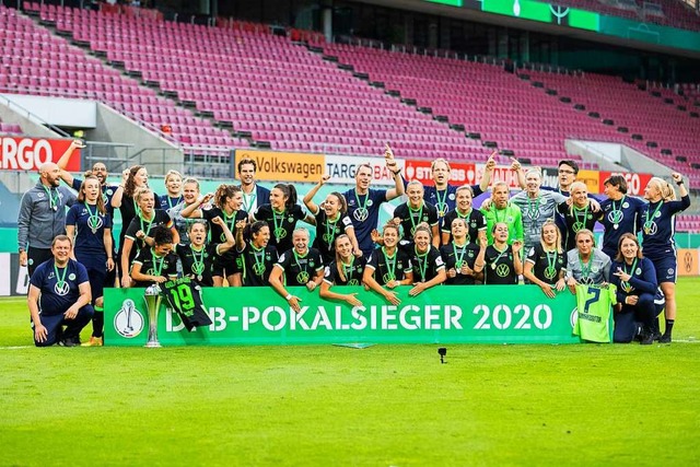 Die Wolfsburgerinnen jubeln nach dem 7...g nach Elfmeterschieen mit dem Pokal.  | Foto: Rolf Vennenbernd (dpa)
