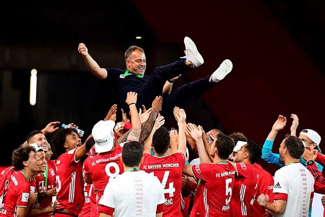Die Bayern-Spieler feiern ihren Trainer Hans Flick nach dem Pokalerfolg.  | Foto: Robert Michael (dpa)