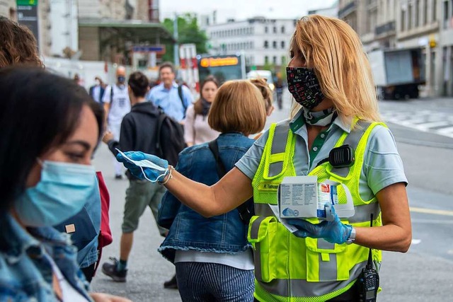 Zum Start verteilten Mitarbeiter der Basler Verkehrs-Betriebe  Schutzmasken.  | Foto: Georgios Kefalas (dpa)