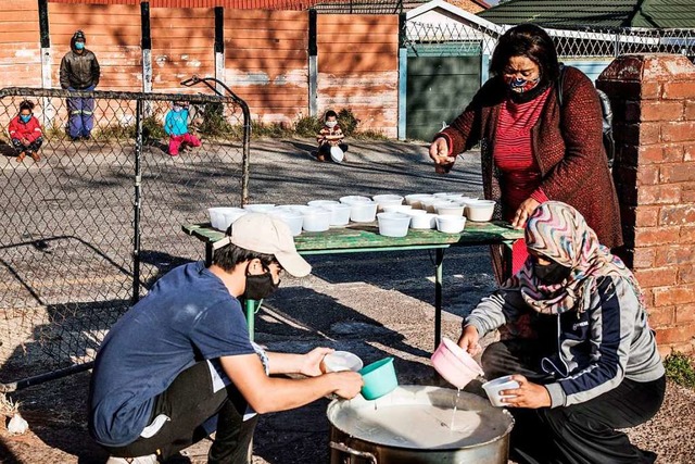 Freiwillige der Organisation &#8222;Hu...g bereiten ein Frhstck fr Kinder zu  | Foto: MARCO LONGARI