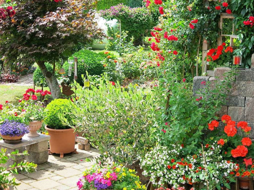 Blumen, Strucher, Bume, Gemse, Kruter und mehr gedeihen im Garten von Ingrid und Herbert Wehrle. Skulpturen, Brunnen, Natursteinmauern, Insektenhotel und Sitzgruppen ergnzen die blhende Oase.