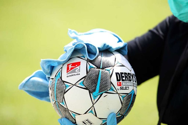 Das Desinfizieren eines Fuballs ist e...n Zuschauer wieder ins Stadion drfen.  | Foto: Alexander Hassenstein (dpa)