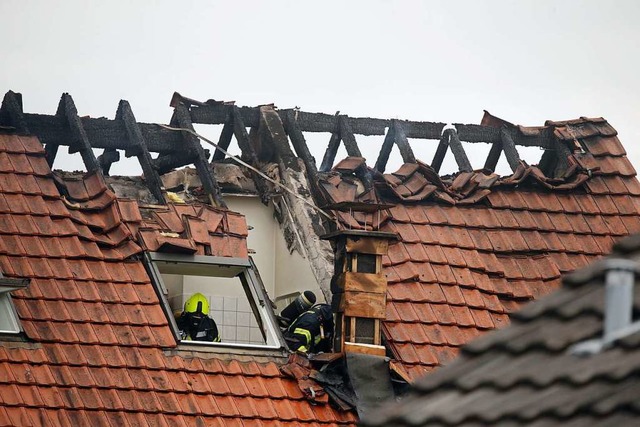 Feuerwehrleute suchen in einem beschdigten Wohnhaus nach Spuren.  | Foto: David Young (dpa)