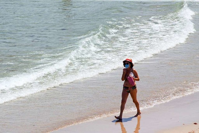 Mit Maske am Strand &#8211; Szenen wie... im Corona-Sommer 2020 hufiger geben.  | Foto: Carlos Castro (dpa)