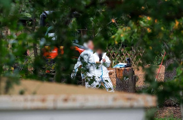 Polizeibeamte durchsuchen eine Kleingarten-Parzelle.  | Foto: Peter Steffen (dpa)