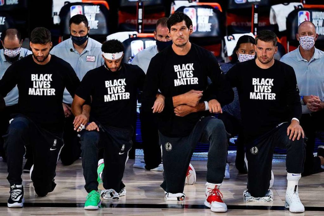 Spieler des Basketballteams Dallas Mav...hrend die Nationalhymne gespielt wird.  | Foto: Ashley Landis (dpa)