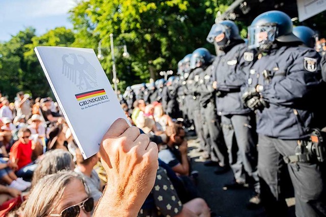 Mahnung mit dem Grundgesetz: Demonstranten stehen Polizisten gegenber.  | Foto: Christoph Soeder (dpa)