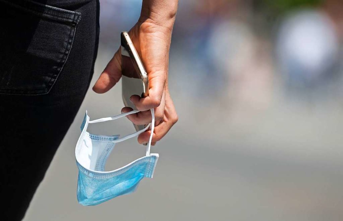 Maske und Corona-Warn-App sind Teil der Schutzstrategie  | Foto: Marijan Murat (dpa)
