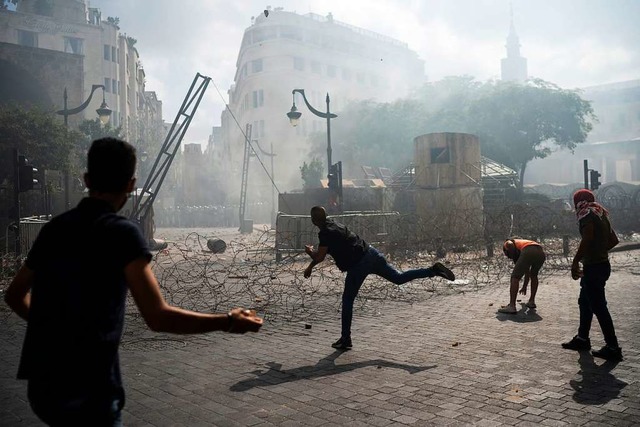 Demonstrierende werfen Steine in Richt... tdlichen Explosion im Hafen Beiruts.  | Foto: Felipe Dana (dpa)