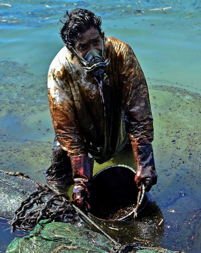 Verzweifelt versuchen Bewohner von Mauritius das l aus dem Wasser zu bekommen.   | Foto: JEAN AURELIO PRUDENCE (AFP)