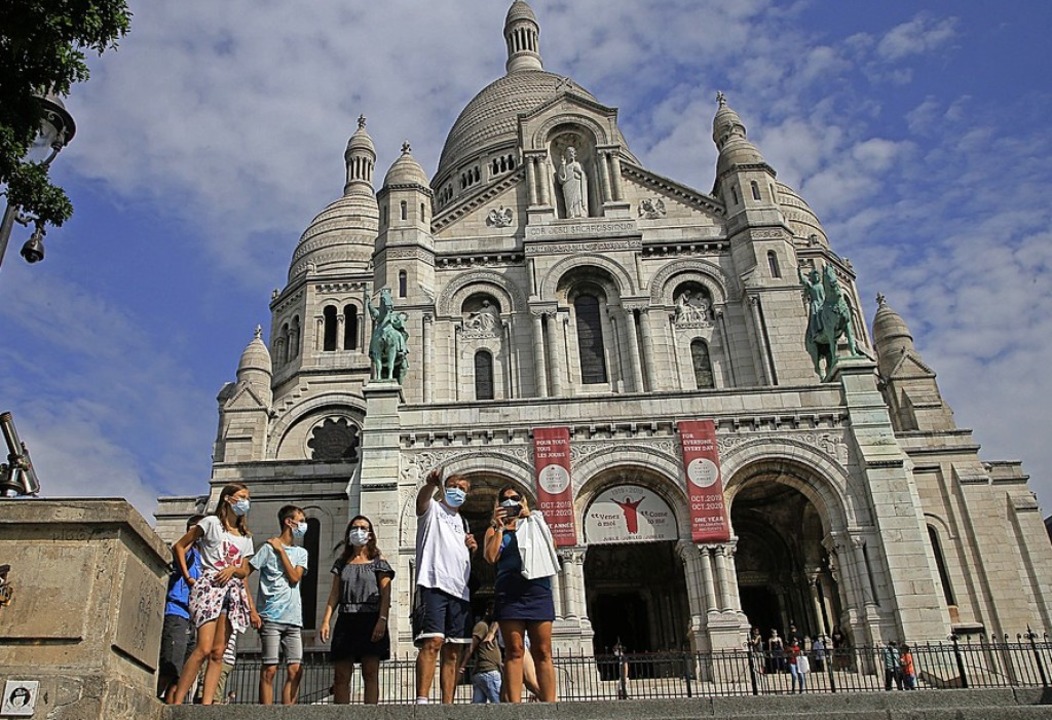Touristen mit Mundschutz stehen vor der Sacré-Coeur de Montmartre    | Foto: Michel Euler (dpa)