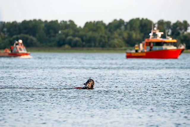 An der Stelle, wo der oder die Vermiss...ehen die Rettungstaucher unter Wasser.  | Foto: Jonas Walzberg (dpa)