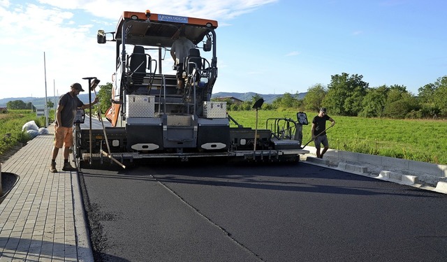 Arbeiter tragen die neue Asphaltschicht auf die Verbindungsstrae in Wyhl auf.   | Foto: Roland Vitt