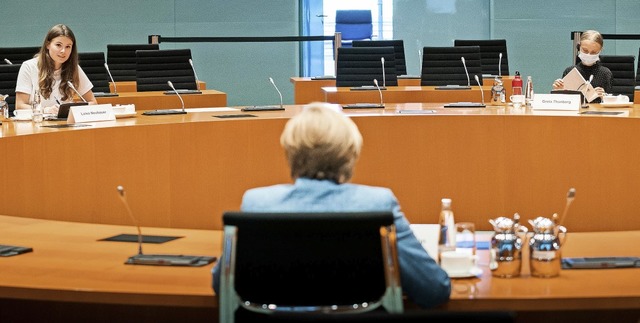 Merkel bespricht sich im Konferenzsaal... (rechts) und Luisa Neubauer (links).   | Foto: Steffen Kugler (dpa)