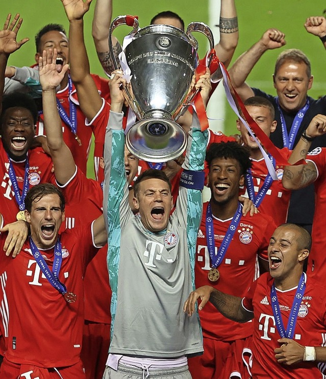 Die Bayern um Kapitn Manuel Neuer mit dem Objekt der Begierde  | Foto: Julian Finney (dpa)