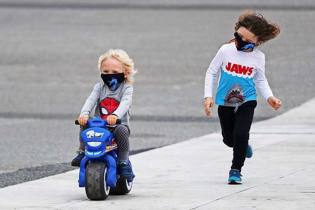 Auch Kinder sind von den Sicherheitsre...ese beiden tragen beim Spielen Masken.  | Foto: Gao Jing (dpa)