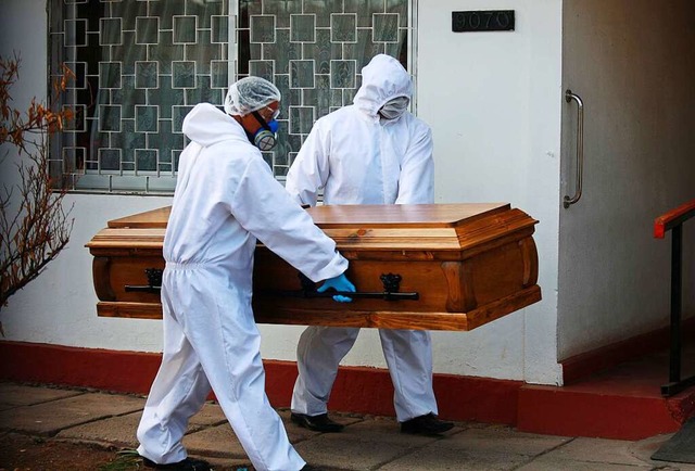Arbeiter betreten ein Pflegeheim in Sa...onavirus gestorbenen Person abzuholen.  | Foto: Jose Francisco Zuiga (dpa)