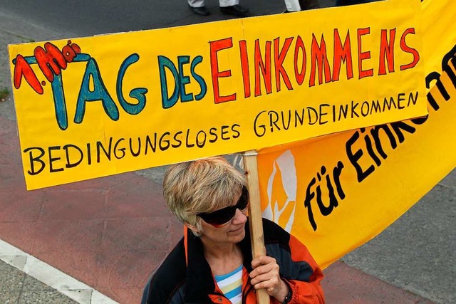 Eine Frau demonstriert fr das Bedingu... Grundeinkommens berwiegend kritisch.  | Foto: Wolfgang Kumm